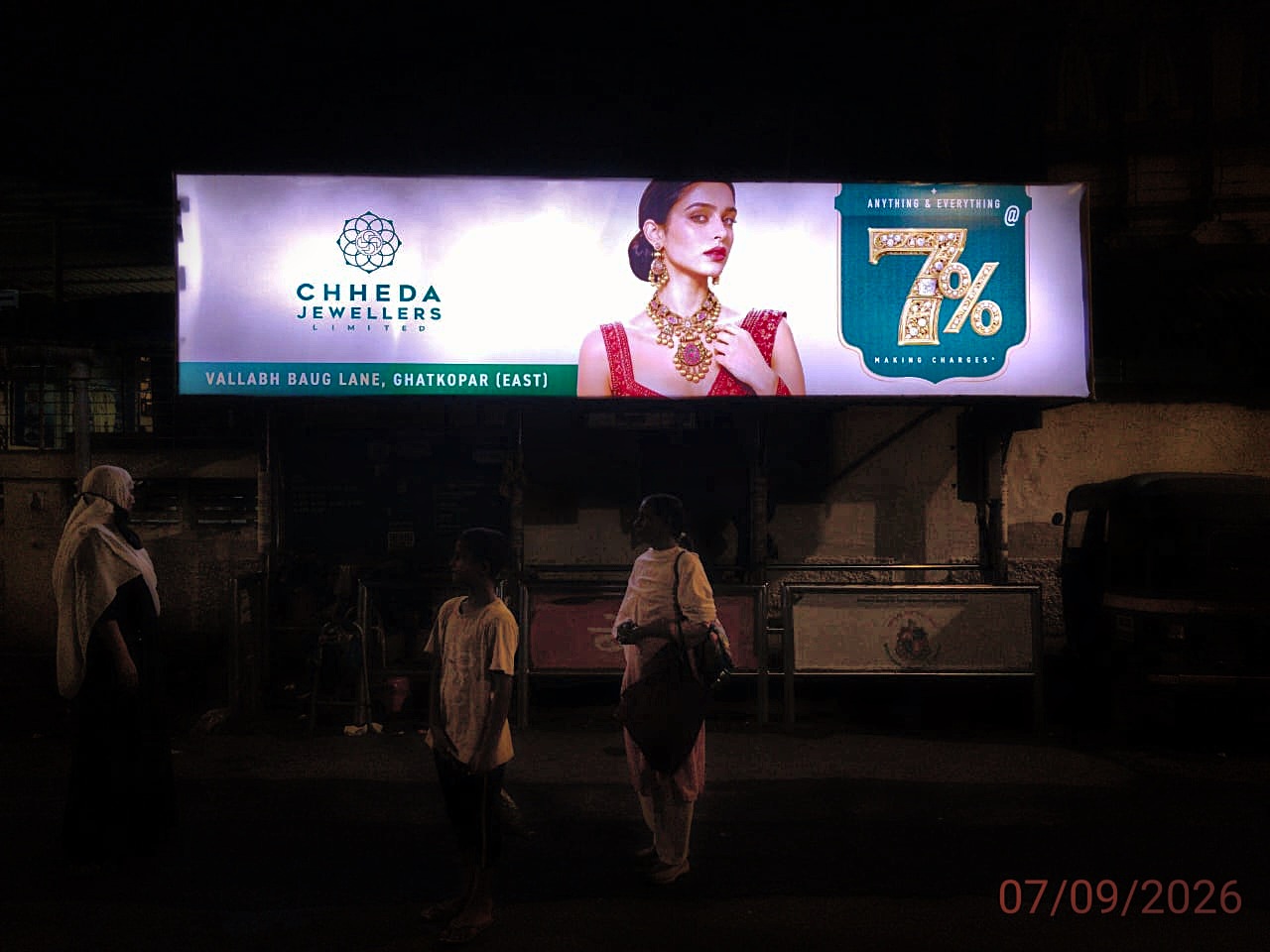 Night-illuminated bus queue shelter billboard in Mumbai